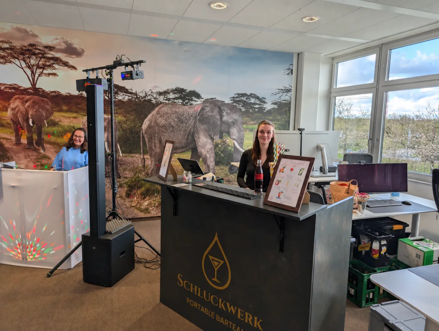 Mobile Cocktailbar von Schluckwerk mit Barkeeperin und DJ-Pult, aufgebaut mitten in einem Büro