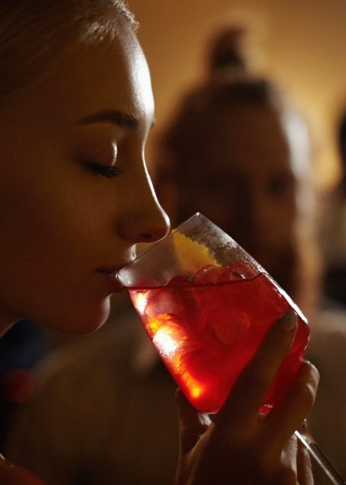 Frau genießt einen Cocktail an einer Bar