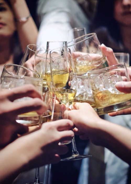 Freunde stoßen mit verschiedenen Cocktails und Weingläsern an